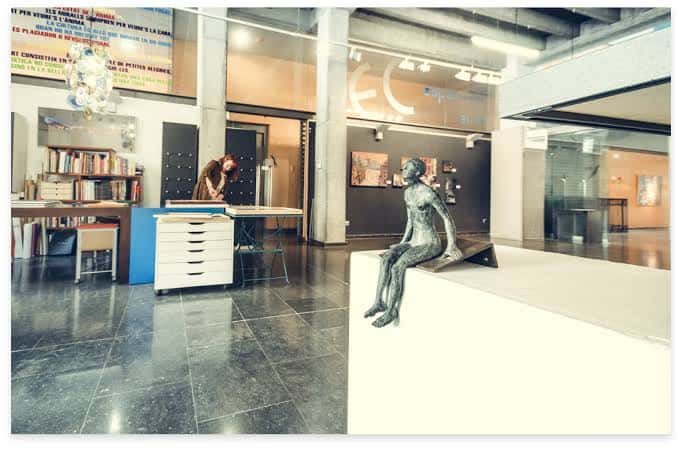 Interior de la galería con una escultura y una persona trabajando