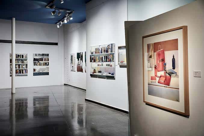 Vista del interior de la galería con una obra de arte en primer plano