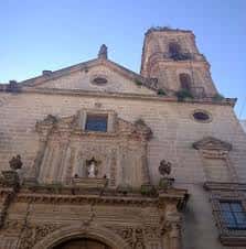 Vista exterior de la fachada y torre de la basílica bajo cielo despejado