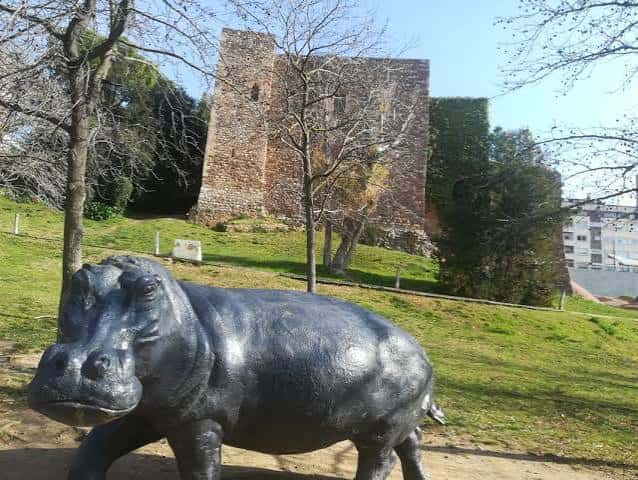 Escultura de hipopótamo frente a la torre medieval del castillo de Terrassa