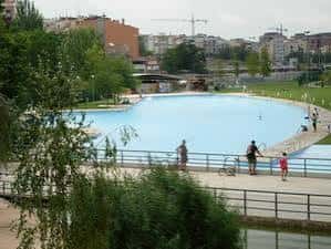 Piscina natural del parque con personas caminando y disfrutando del entorno