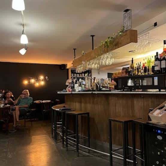 Vista del interior del local con barra y clientes sentados