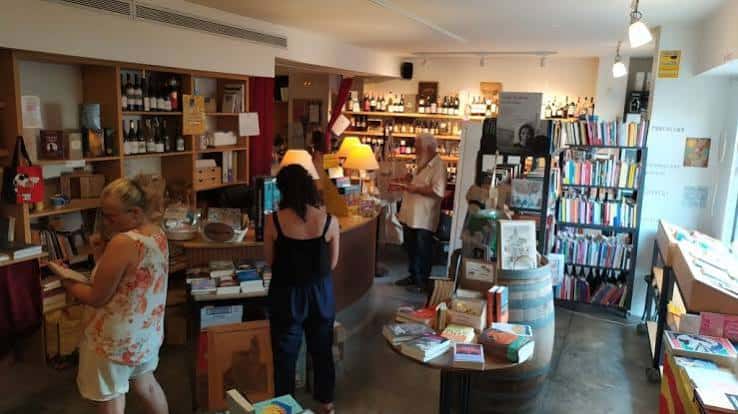 Interior de la librería con estanterías de libros y clientes navegando