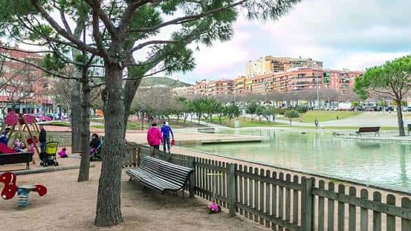 Área de juegos infantiles junto al estanque con familias disfrutando