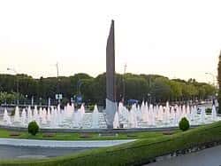 Fuente monumental con chorros de agua y obelisco en el centro del parque