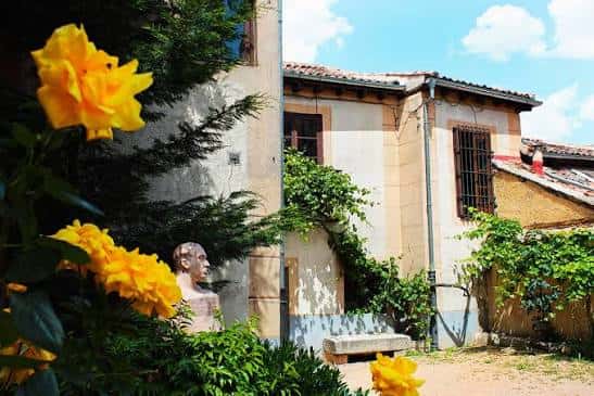 Fachada exterior de la Casa-Museo con jardín y flores amarillas