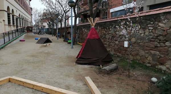 Zona de recreo al aire libre con tienda de campaña y juegos