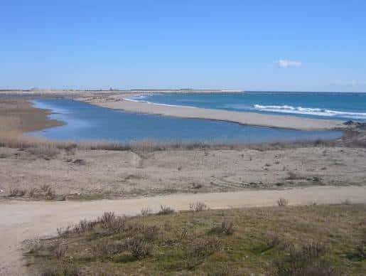 Confluencia de río y mar con arenales y vegetación costera
