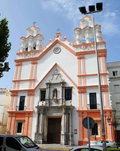 Fachada principal de la Iglesia del Carmen en Cádiz con detalles barrocos y colores blancos y rosados