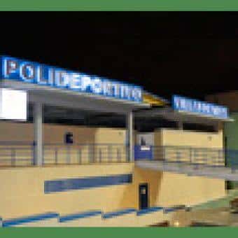 Fachada exterior del Polideportivo Villafontana iluminada por la noche