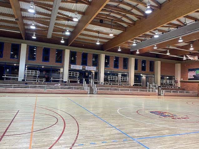 Vista general del interior del polideportivo con pista de baloncesto y gradas