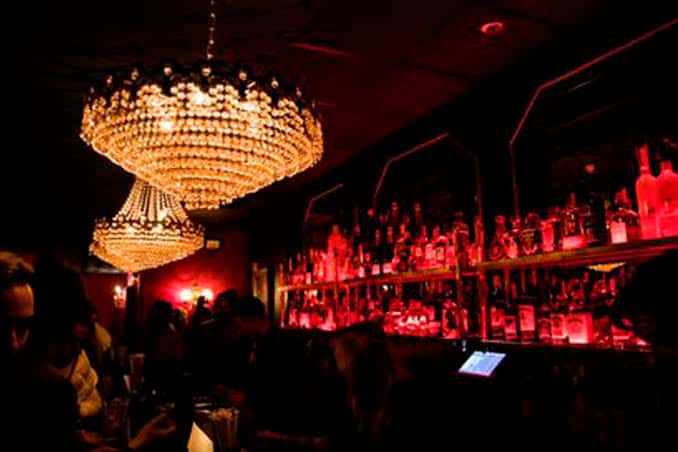 Bar interior del club con lámparas de cristal y estantería de botellas