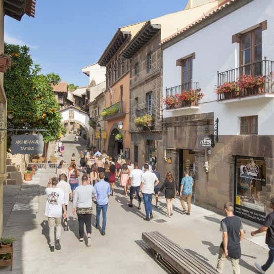 Calle peatonal con arquitectura tradicional española y turistas caminando