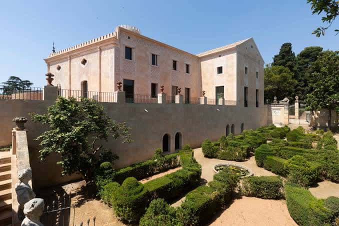 Vista lateral del palacio con sus jardines geométricos y muros de contención