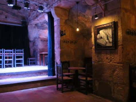 Interior de la Sala Rothus con escenario y mesas de madera