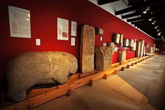 Sala de exposición con esculturas de piedra y paneles informativos