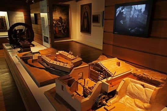 Modelo arquitectónico y artefactos históricos en vitrina