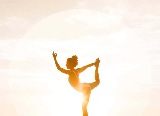 Silueta de mujer en postura de yoga al atardecer