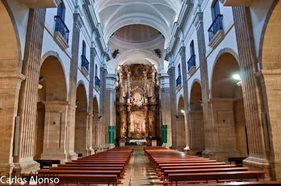 Interior de la nave central con el retablo mayor y bancos de madera