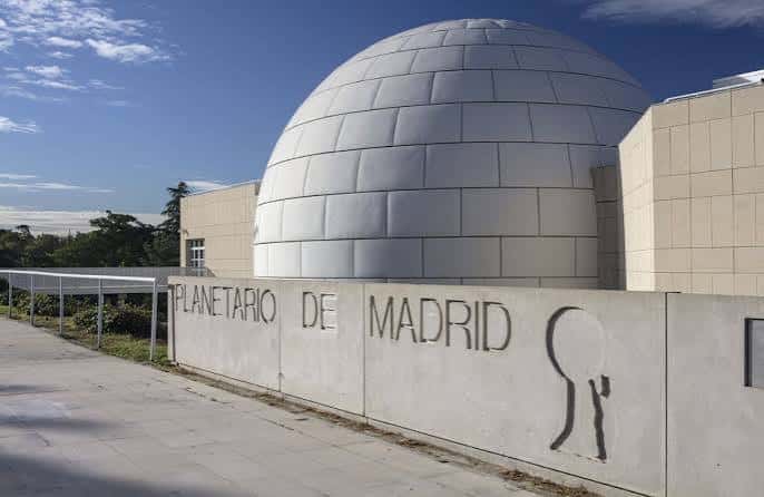 Fachada del Planetario de Madrid con letrero institucional y cielo azul