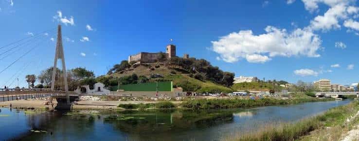 Castillo Sohail en la colina con puente y río en primer plano