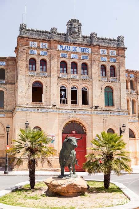 Fachada principal de la Plaza de Toros con la estatua del toro y palmeras