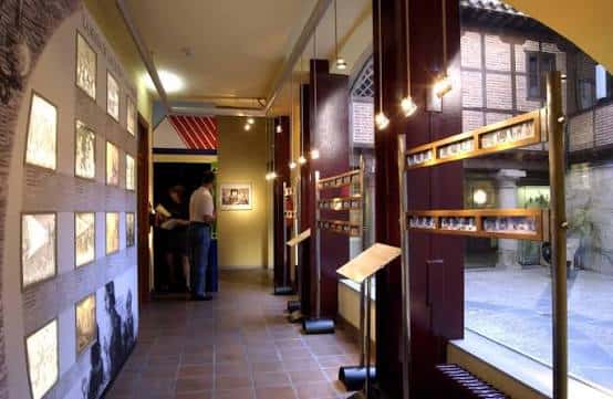 Interior de la Filmoteca mostrando pasillo con exposiciones fotográficas y vitrinas de películas