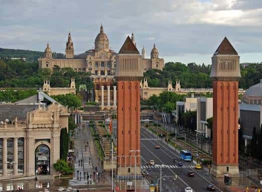 Perspectiva elevada de la avenida en un día nublado, destacando la arquitectura monumental y el tráfico urbano