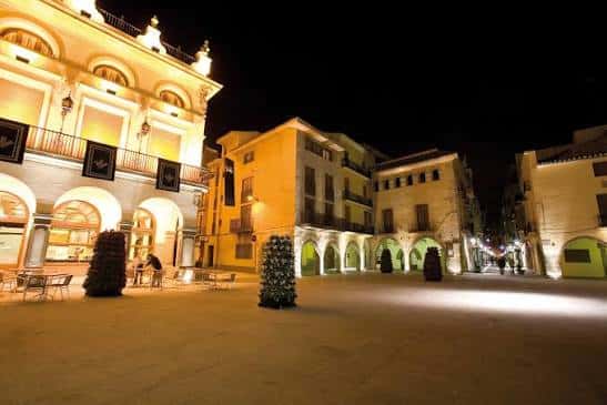 Plaza de la Vila iluminada por la noche, ambiente festivo con decoración navideña