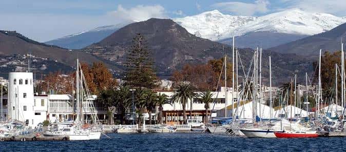 Puerto deportivo de Motril con veleros amarrados y Sierra Nevada nevada al fondo
