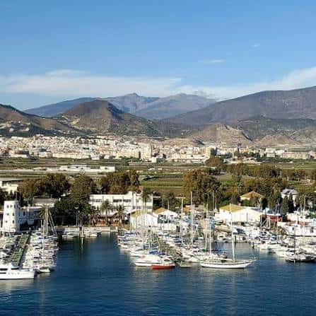 Vista panorámica del puerto de Motril con embarcaciones y la ciudad en el horizonte