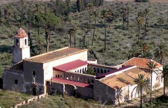 Vista aérea del Monasterio de San Ginés de la Jara rodeado de palmeras y vegetación mediterránea
