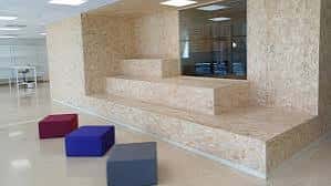 Área de descanso con escalones de madera y cojines de colores