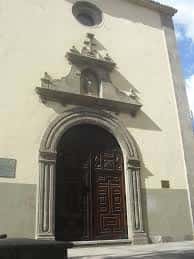 Entrada principal del edificio con puerta de madera y detalles arquitectónicos