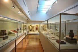 Sala de exposiciones con vitrinas de arte precolombino y iluminación cenital