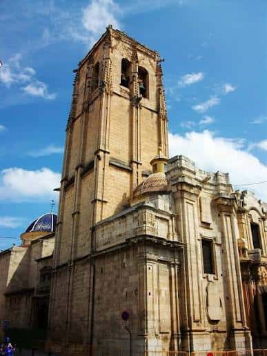Vista exterior de la torre campanario de la Iglesia Parroquial de las Santas Justa y Rufina bajo cielo azul