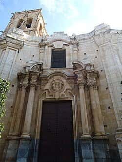 Fachada principal de la iglesia con puerta de madera y detalles arquitectónicos barrocos
