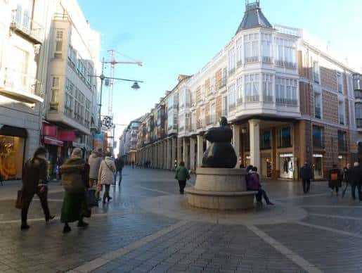 Plaza de la Calle Mayor con la escultura de la mujer sentada y edificios históricos al fondo