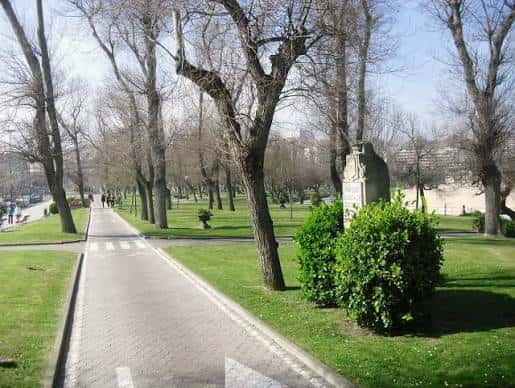 Vista del parque con sendero, césped y monumento central