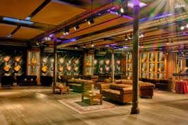 Interior del Aclam Club con decoración de guitarras y zona de lounge
