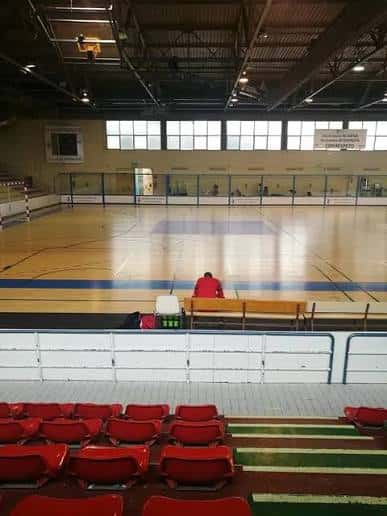 Pabellón deportivo interior con pista de baloncesto y gradas