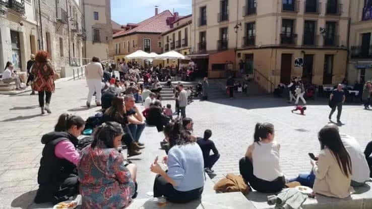Plaza de Don Gutierre animada con personas sentadas en las gradas disfrutando de un día soleado
