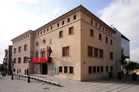 Fachada principal del edificio de la plaza con banderas