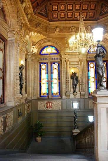 Interior del hall principal con escalera, vitrales y decoración clásica