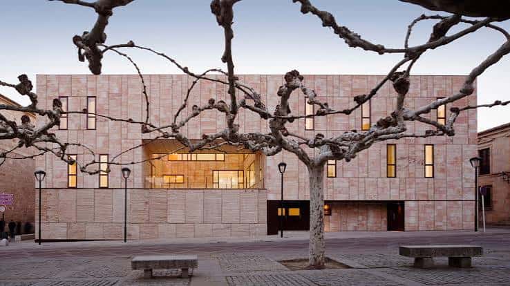 Fachada moderna de la Diputación Provincial de Zamora al atardecer con árboles en primer plano