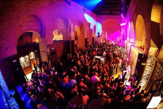 Evento concurrido en el Círculo de Arte con iluminación vibrante y ambiente festivo