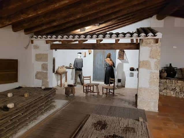 Interior del museo con techos de vigas de madera y exposiciones de vida rural tradicional
