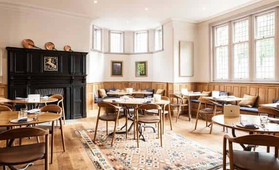 Sala de comedor elegante con chimenea y grandes ventanales