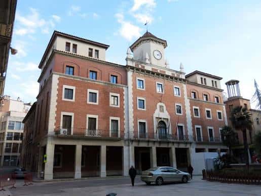 Vista frontal del Ayuntamiento de Tortosa con fachada de ladrillo y torre del reloj