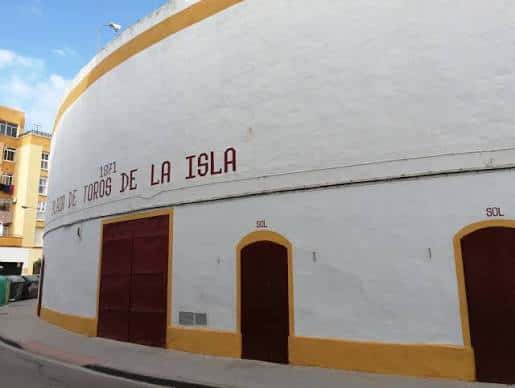 Vista exterior de la Plaza de Toros de San Fernando con fachada blanca y detalles amarillos